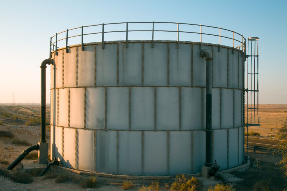A large white water tank in the desert